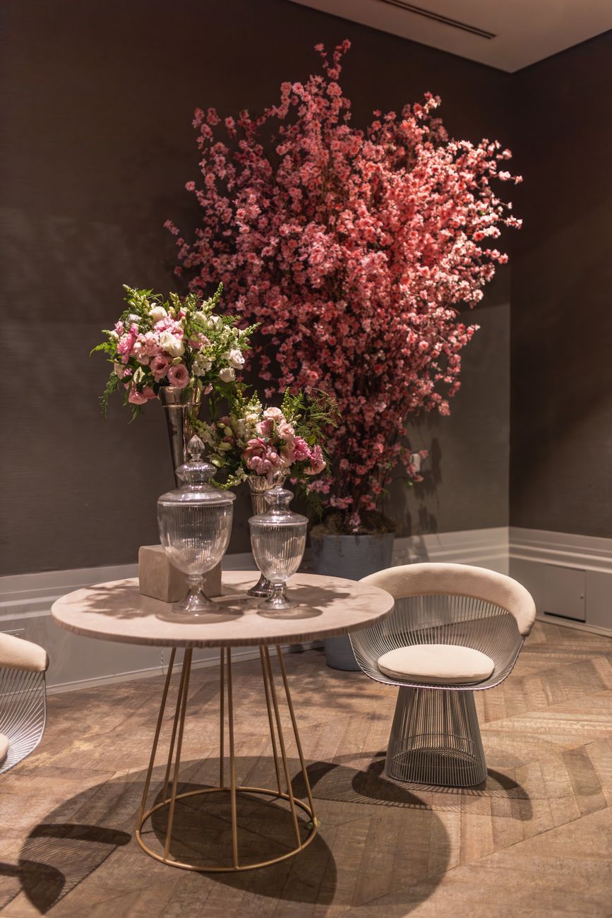 Interior elegante con mesa redonda y plantas frondosas